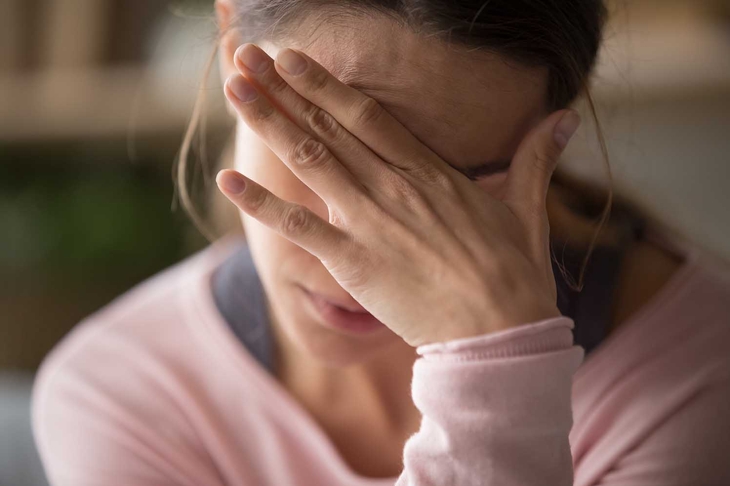 Sad tired young woman touching forehead having headache migraine or depression, upset frustrated girl troubled with problem feel stressed cover crying face with hand suffer from grief sorrow concept