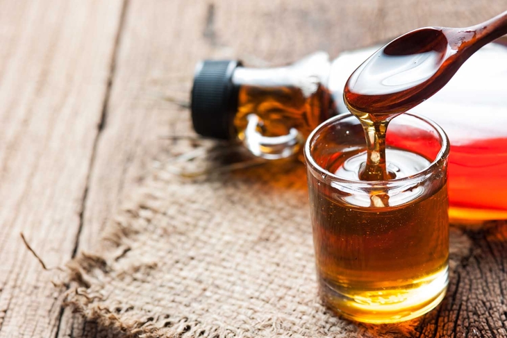 maple syrup in glass bottle on wooden table