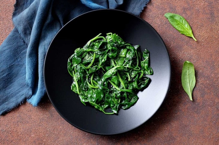 vegetarian food cooked spinach in black dish