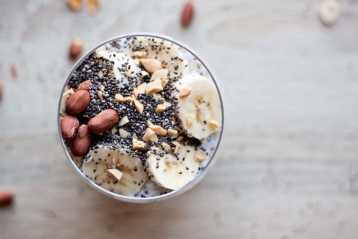 Banana chia yogurt pudding decorated with ripe sliced banana and peanuts