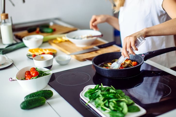 Young blonde woman cooking in the kitchen. Healthy Food. Dieting Concept. Healthy Lifestyle. Cooking At Home. Prepare Food